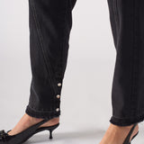 Close-up on the popper ankle detail and frayed hem of Black Wash Straight Leg Jeans
