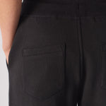 Detailed view of the back pocket on the black tapered joggers