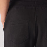 Detailed view of the back pocket on the black tapered joggers