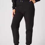 A woman wearing stylish black tapered joggers womens in a front view shot.
