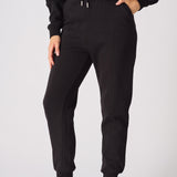 A woman wearing stylish black tapered joggers womens in a front view shot.