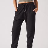 Front view of the black tapered joggers for women, showing the logo and fit.