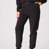 A woman walking comfortably in black tapered joggers womens for a casual look.