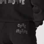 Detailed shot showing the printed text on the back of the black tapered joggers womens.