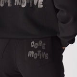 Detailed shot showing the printed text on the back of the black tapered joggers womens.