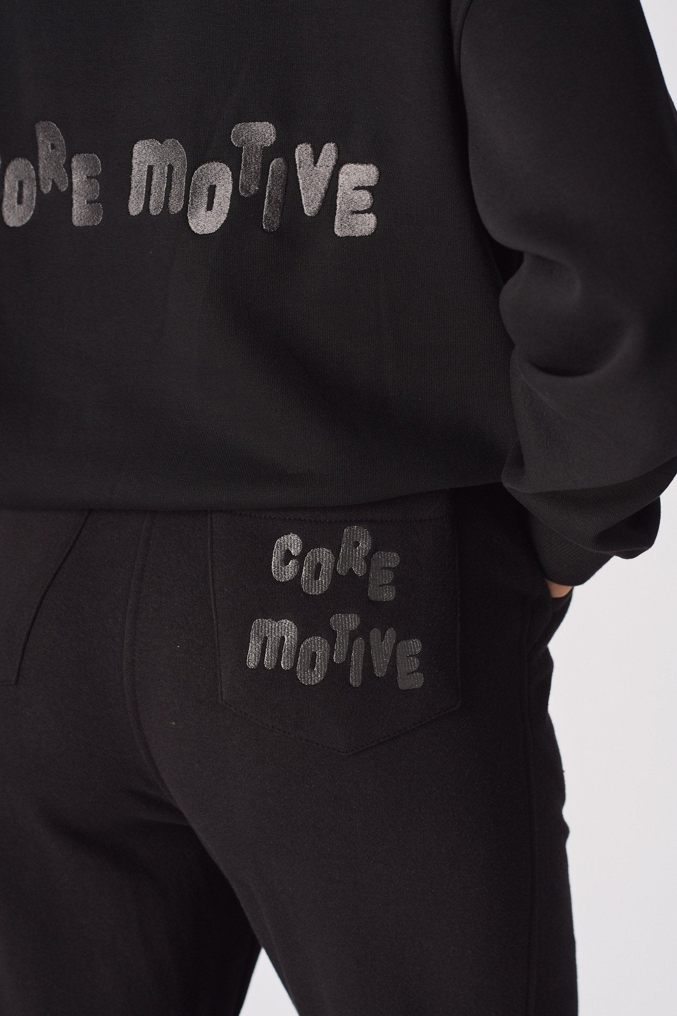 Detailed shot showing the printed text on the back of the black tapered joggers womens.