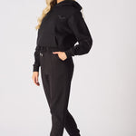 Side profile of a woman wearing comfortable black tapered joggers womens.