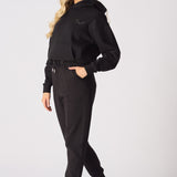 Side profile of a woman wearing comfortable black tapered joggers womens.