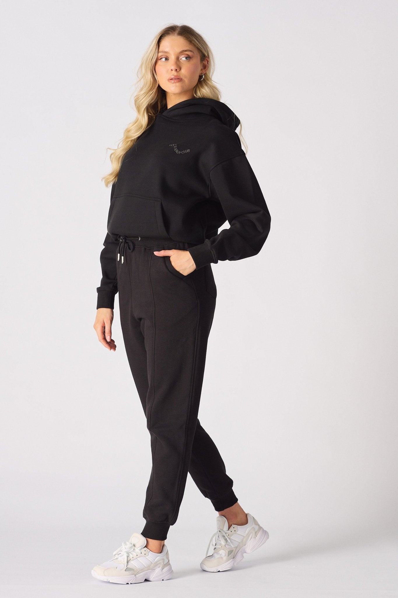 Side profile of a woman wearing comfortable black tapered joggers womens.