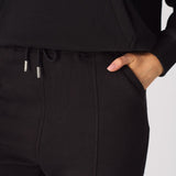 Close up showing the adjustable drawstring waist of the black tapered joggers womens.