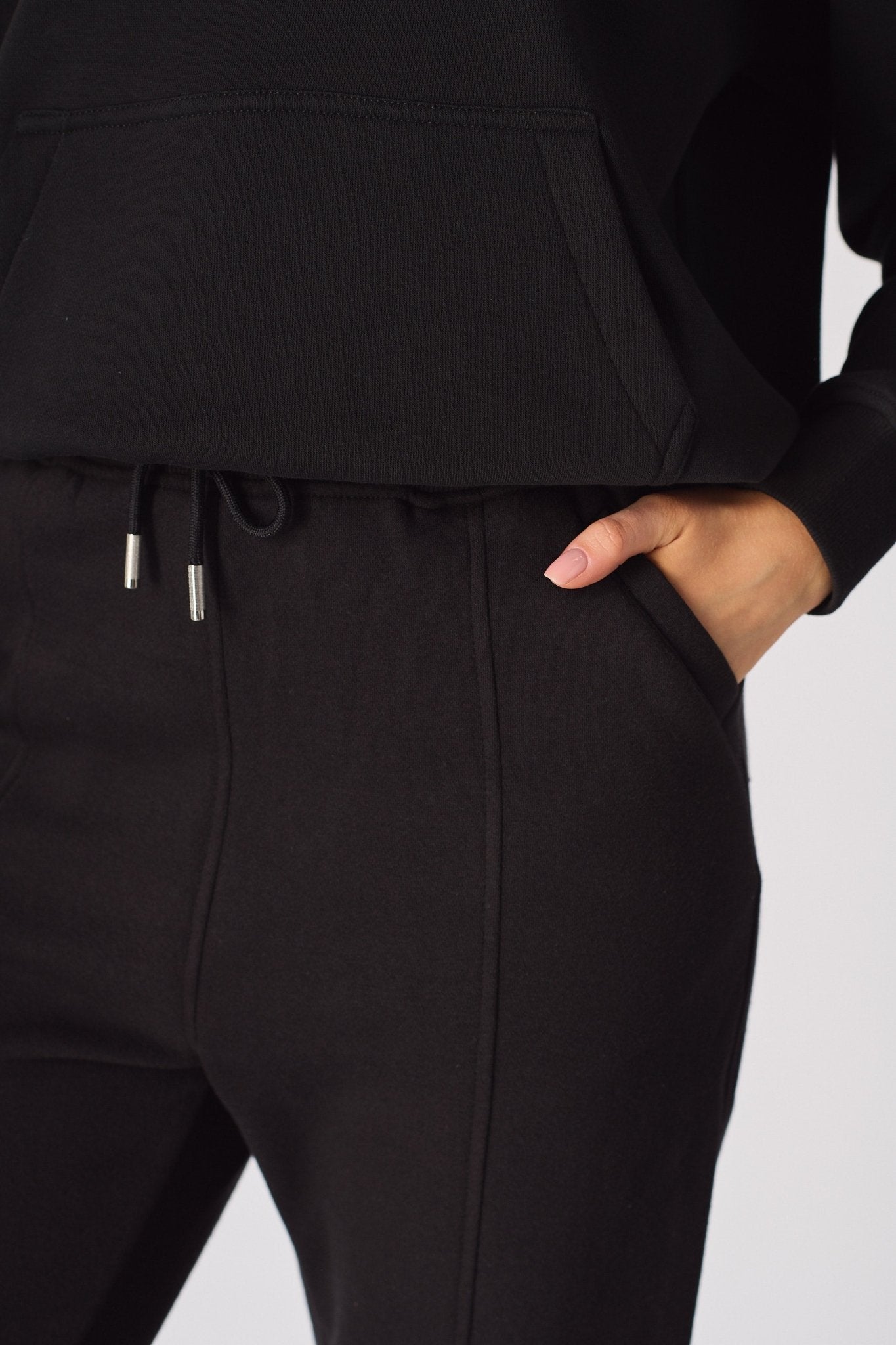 Close up showing the adjustable drawstring waist of the black tapered joggers womens.