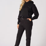 A model walking forward while wearing premium black tapered joggers womens.