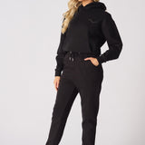 A model walking forward while wearing premium black tapered joggers womens.