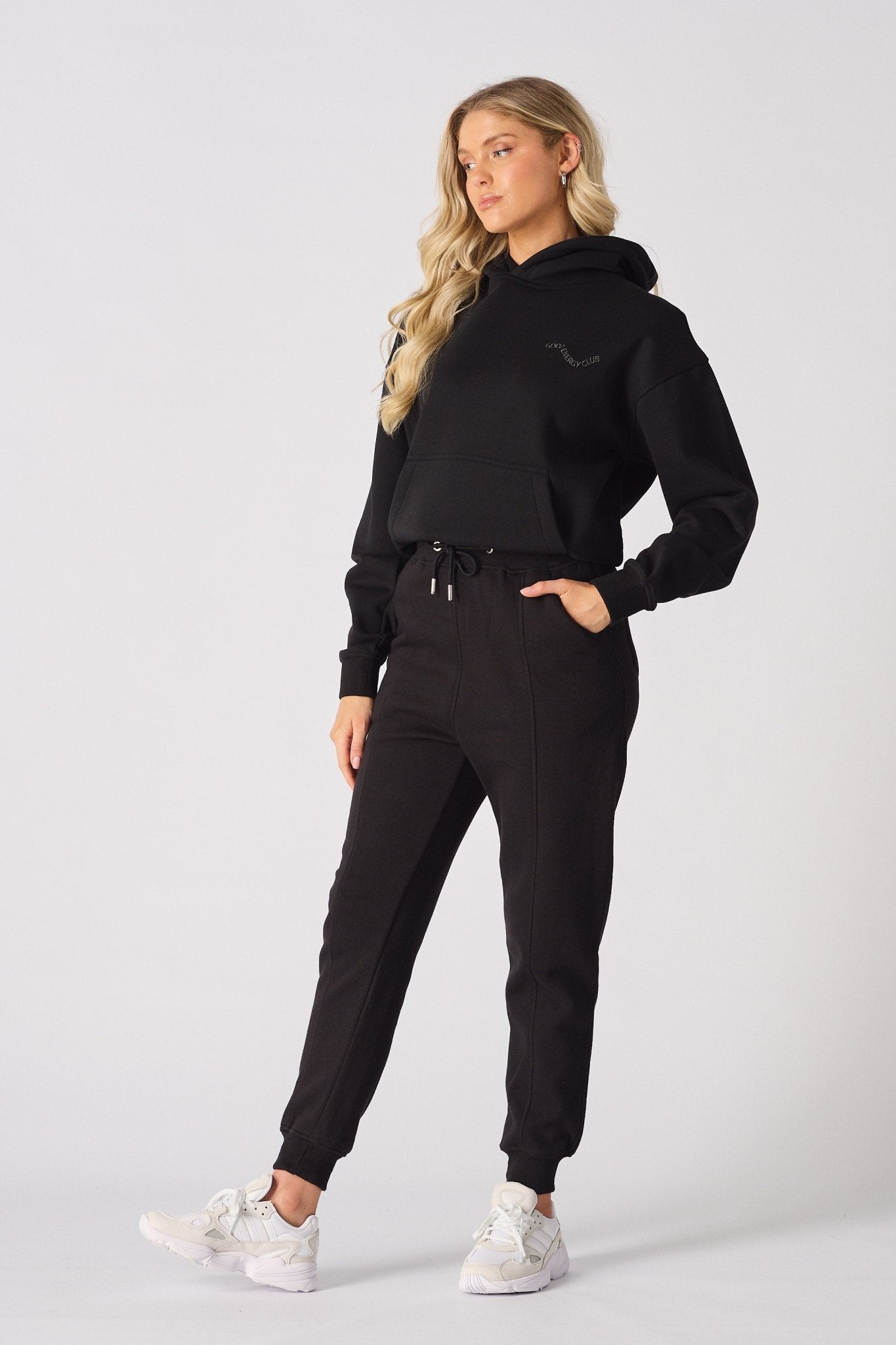 A model walking forward while wearing premium black tapered joggers womens.