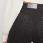 Close up of back pockets and brand patch on Black Wash Curved Seam Straight Leg Jeans