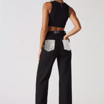 Angled back view showing silver embellished pocket details on black wide leg jeans