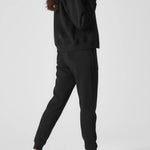 Rear view showing the relaxed oversized fit and hood of the black zip up hoodie womens.