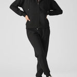 Front view of a model posing in a stylish black zip up hoodie womens.