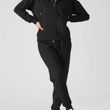 Front view of a model posing in a stylish black zip up hoodie womens.