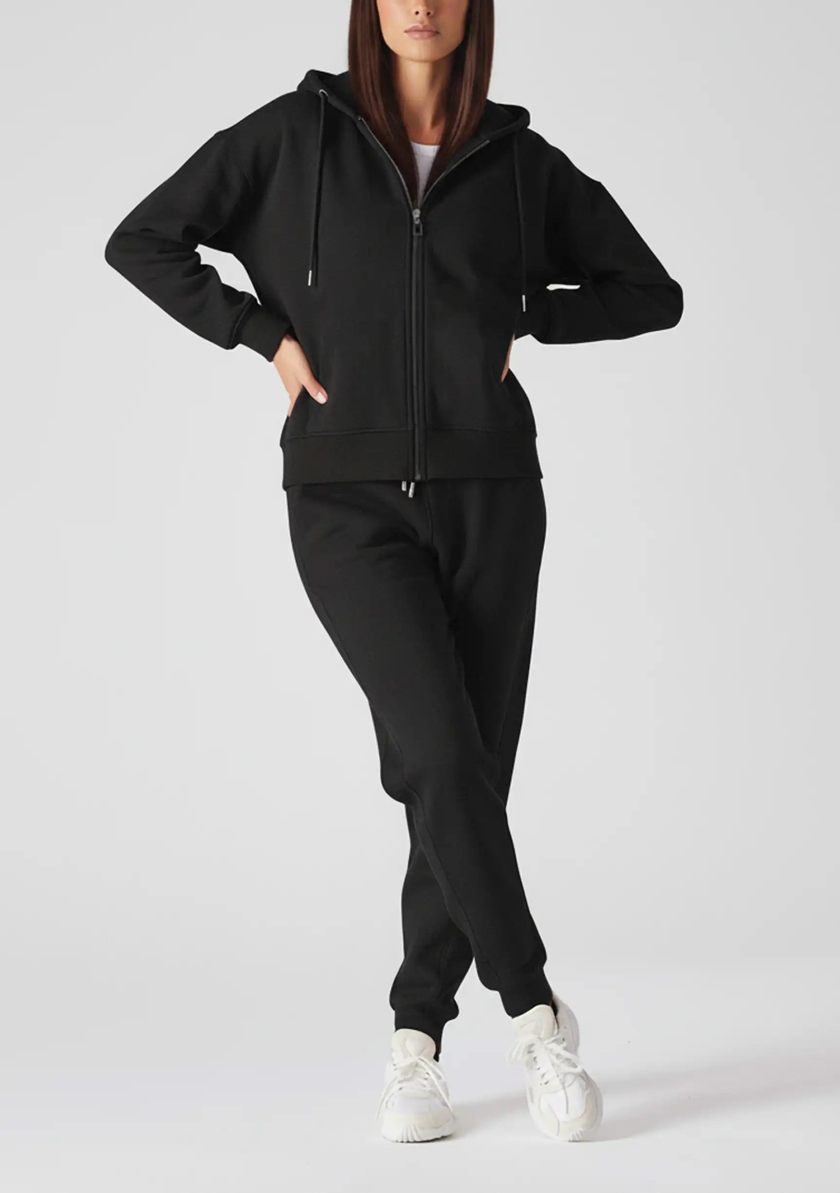 Front view of a model posing in a stylish black zip up hoodie womens.