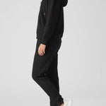 Side profile of a woman wearing a comfortable black zip up hoodie womens.