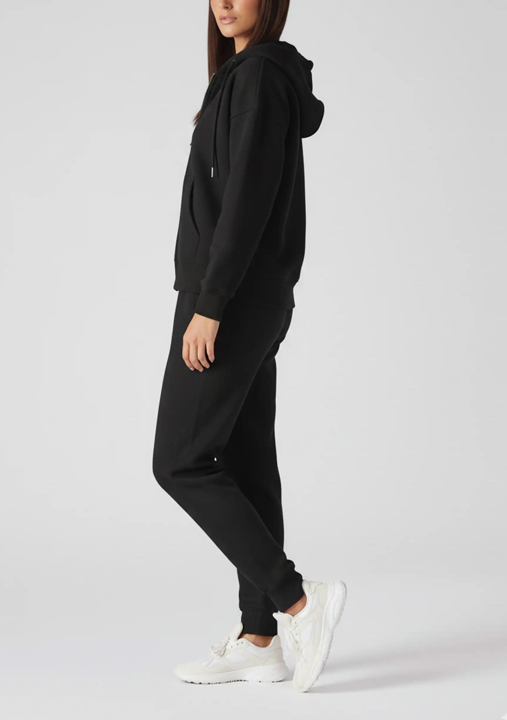 Side profile of a woman wearing a comfortable black zip up hoodie womens.