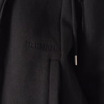 Close up showing the discreet tonal embroidery and pocket on the black zip up hoodie womens.