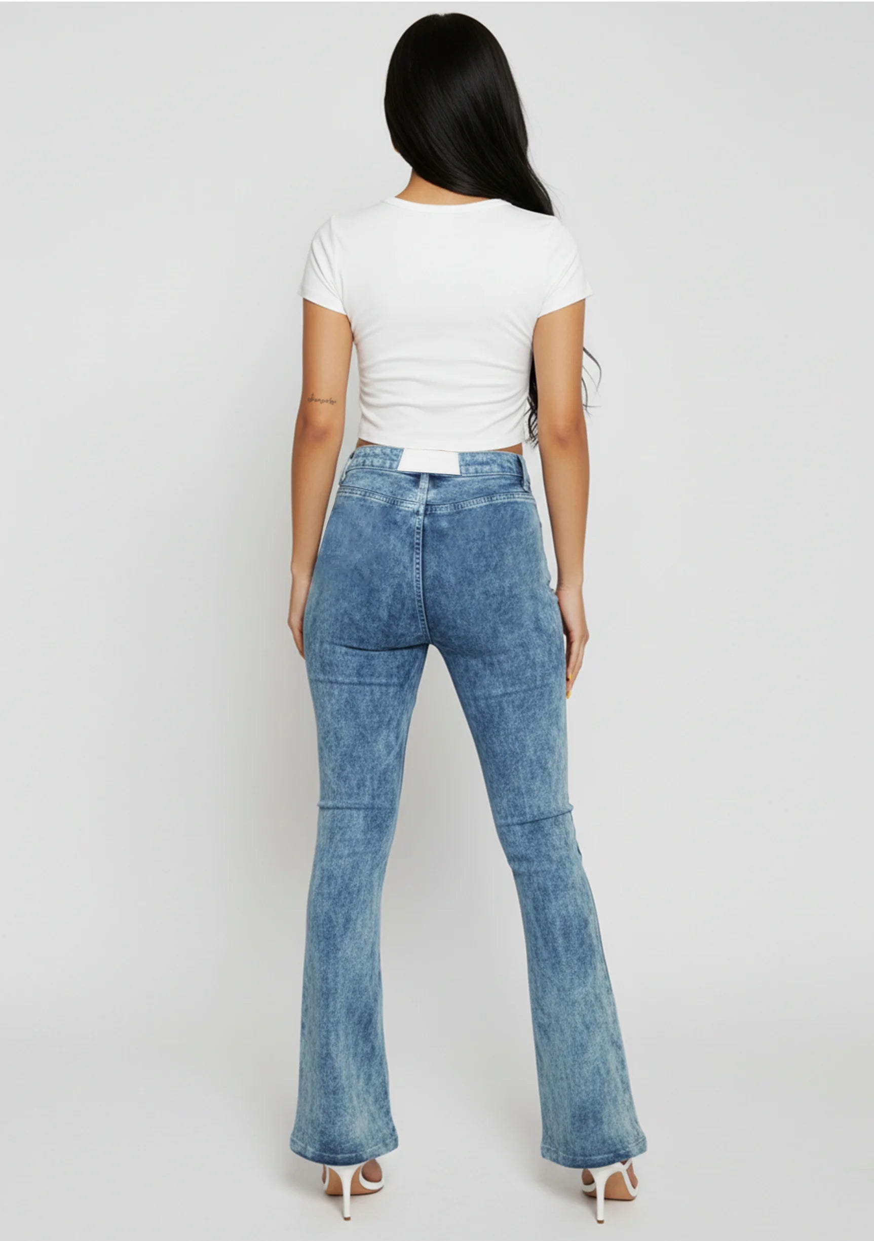 Back view of women's blue acid wash jeans featuring a pocketless design
