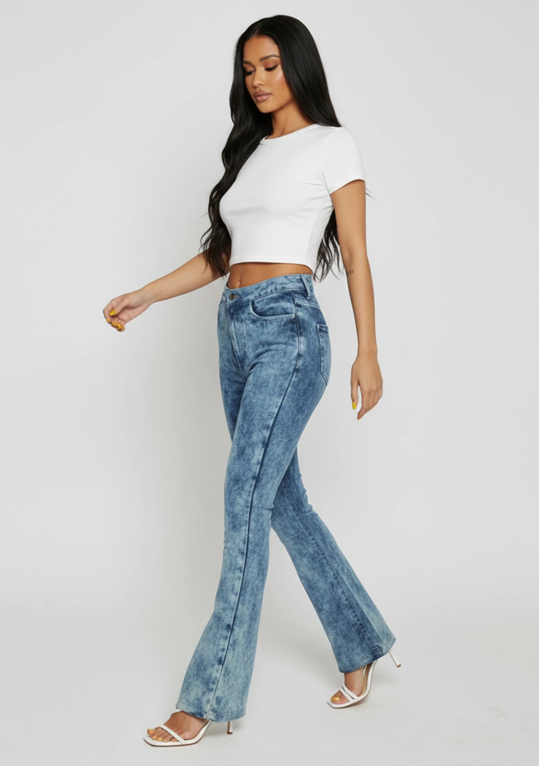 Side profile view of women's blue acid wash bootcut denim