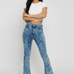 Model with arms crossed wearing fitted blue acid wash bootcut jeans