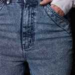 Close-up of the unique front pocket design on the blue acid wash jeans