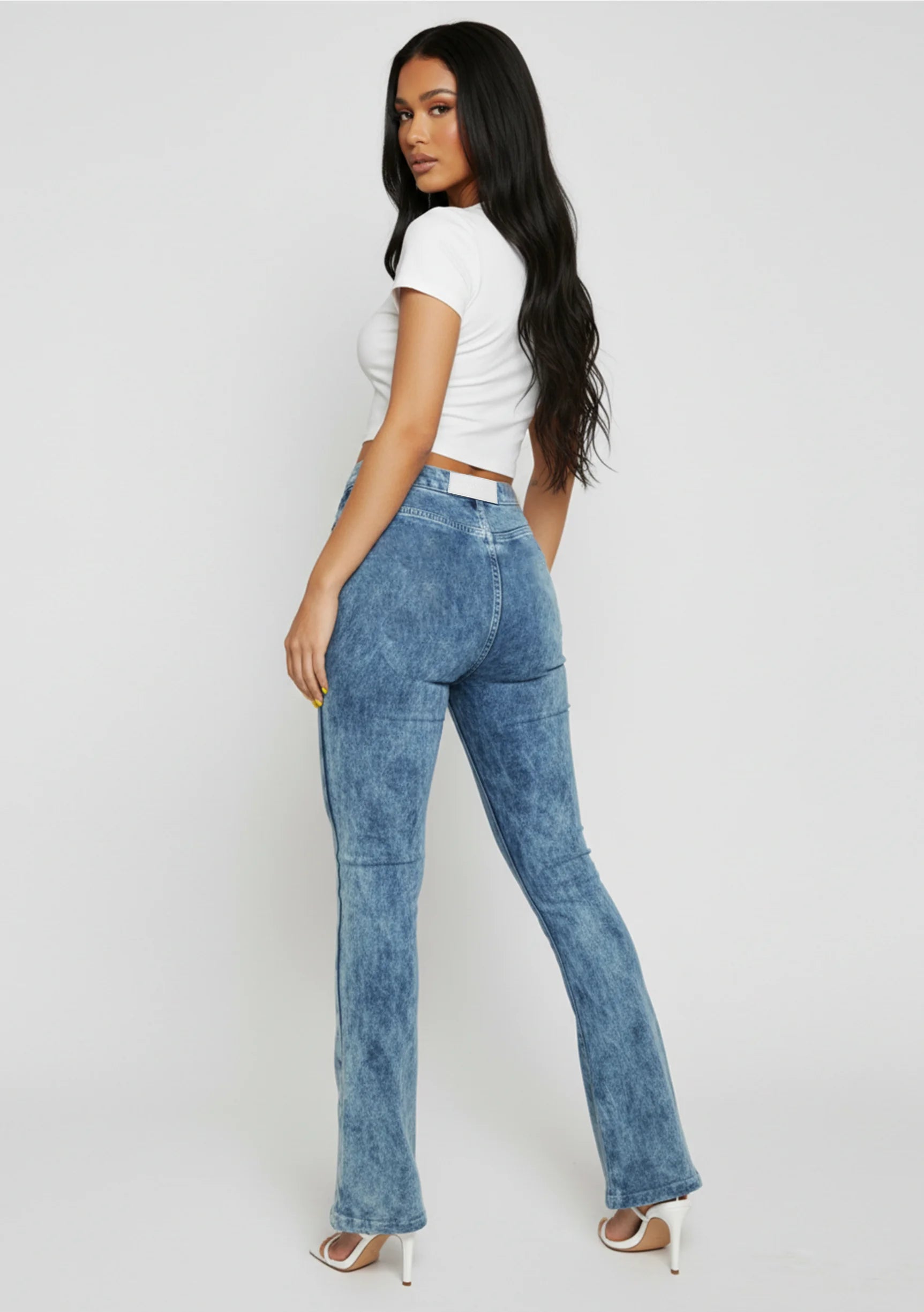 Full front view of a model in trendy blue acid wash bootcut jeans