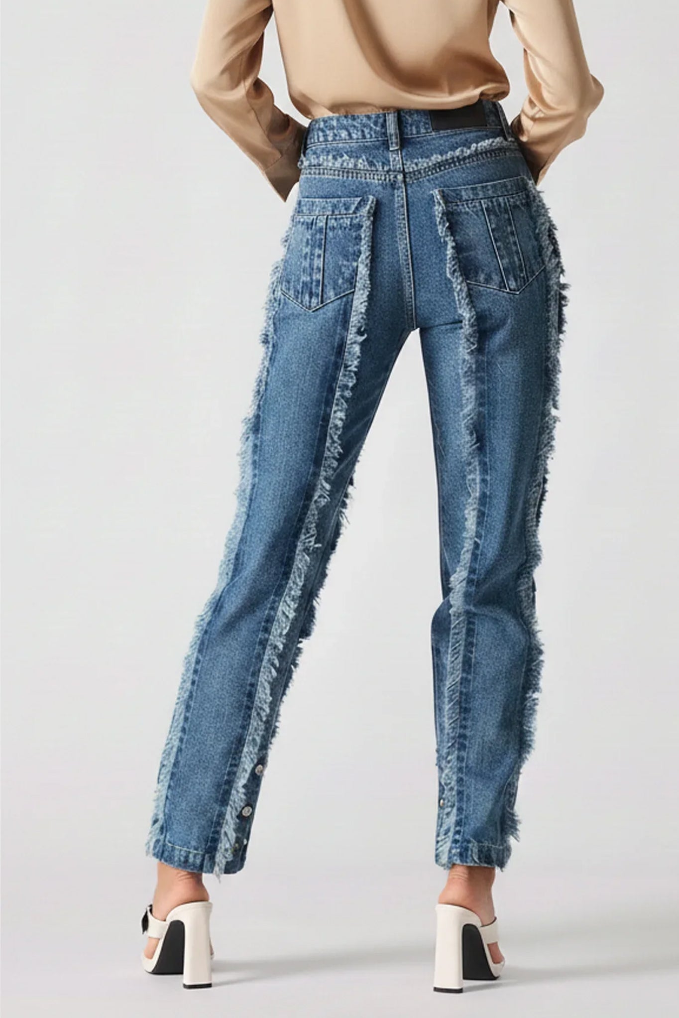 Blue distressed jeans worn by a person on a white background