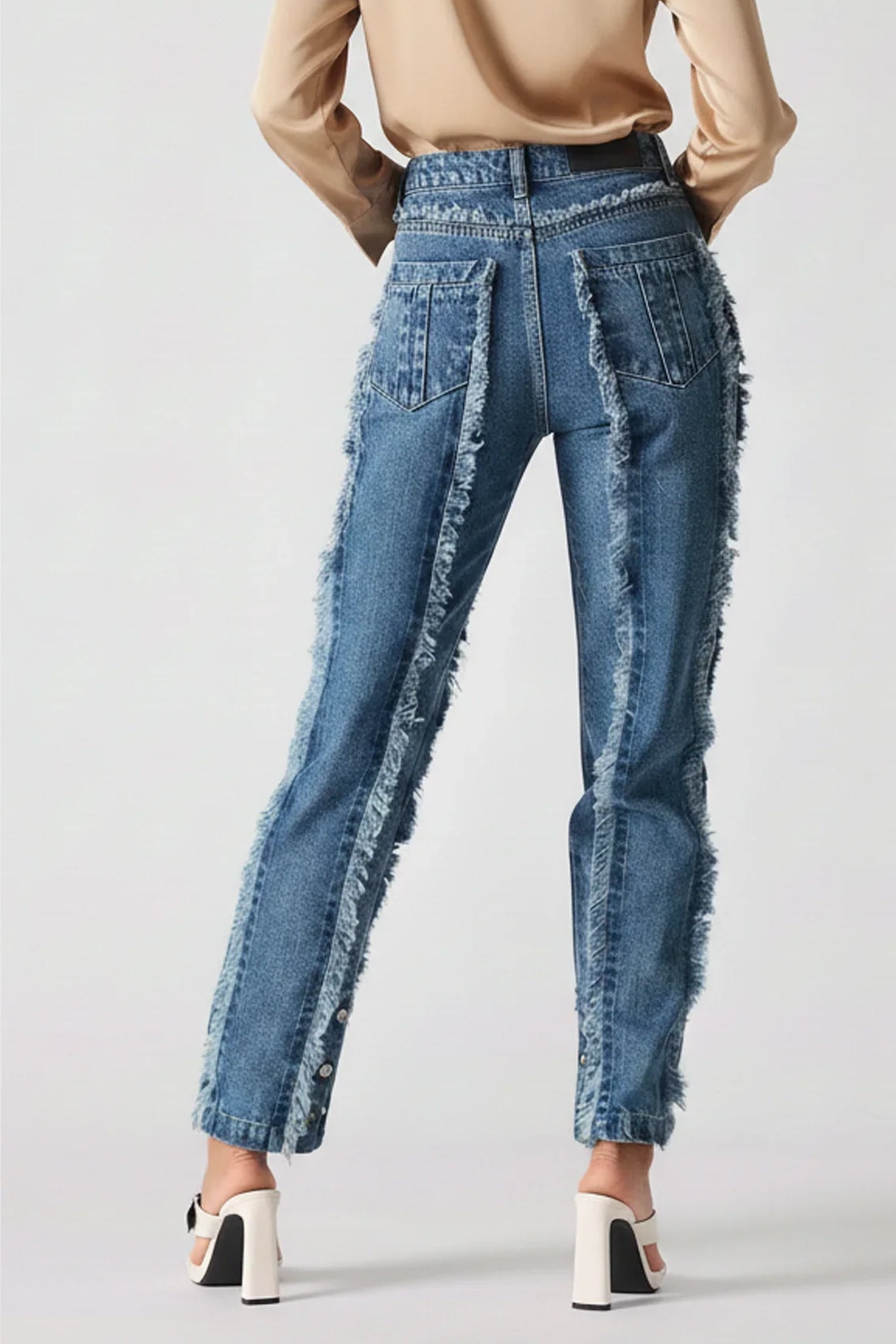 Blue distressed jeans worn by a person on a white background
