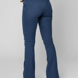 Person wearing blue flared jeans on a plain background
