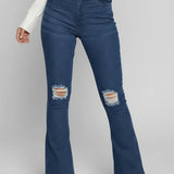 Blue flared jeans with distressed details worn by a person on a white background