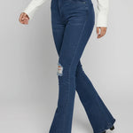 Person wearing blue flared jeans on a plain background