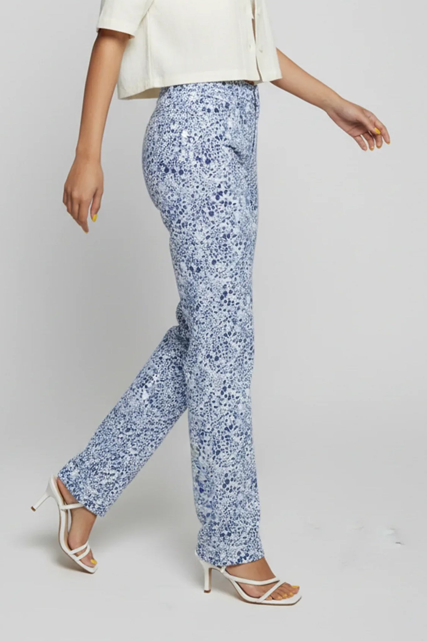 Person wearing blue floral pants on a plain background