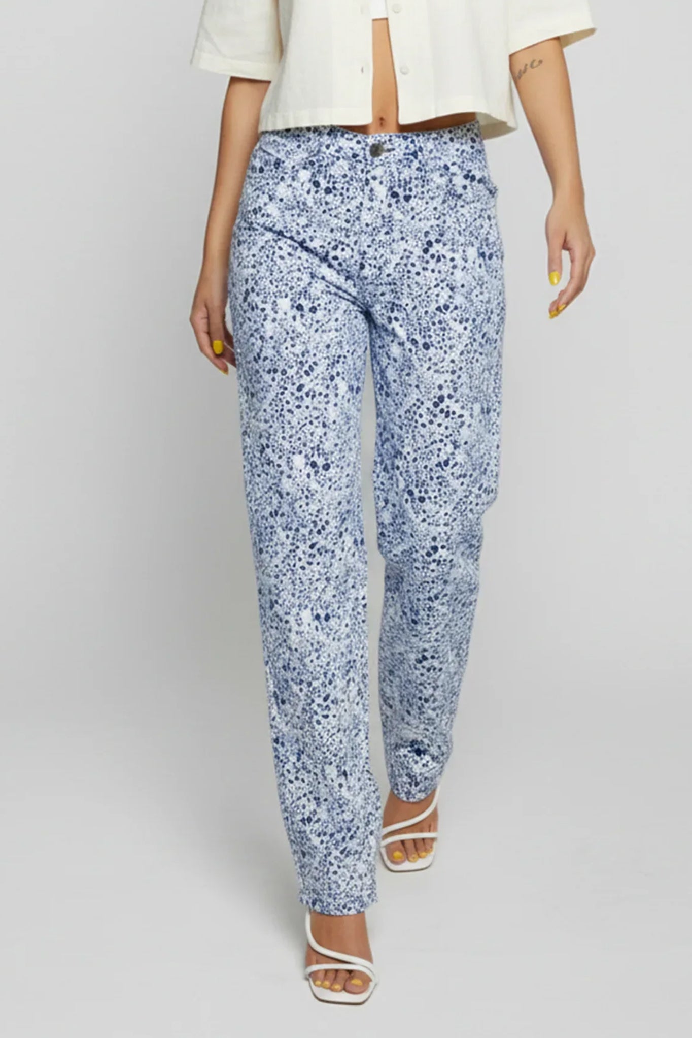 Person wearing blue floral pants on a white background