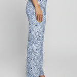 Person wearing blue floral pants on a plain background