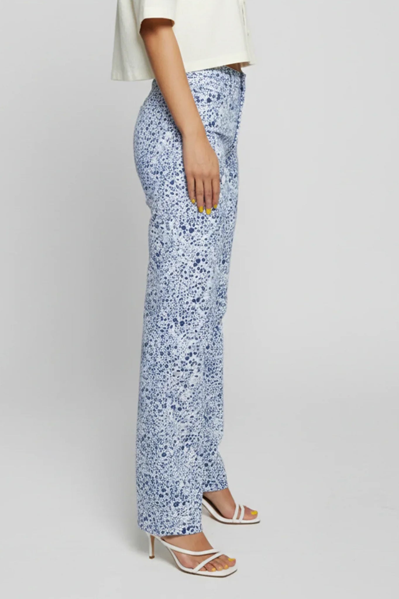 Person wearing blue floral pants on a plain background