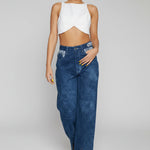Close up of the button closure and belt loops on blue acid wash high-waisted jeans