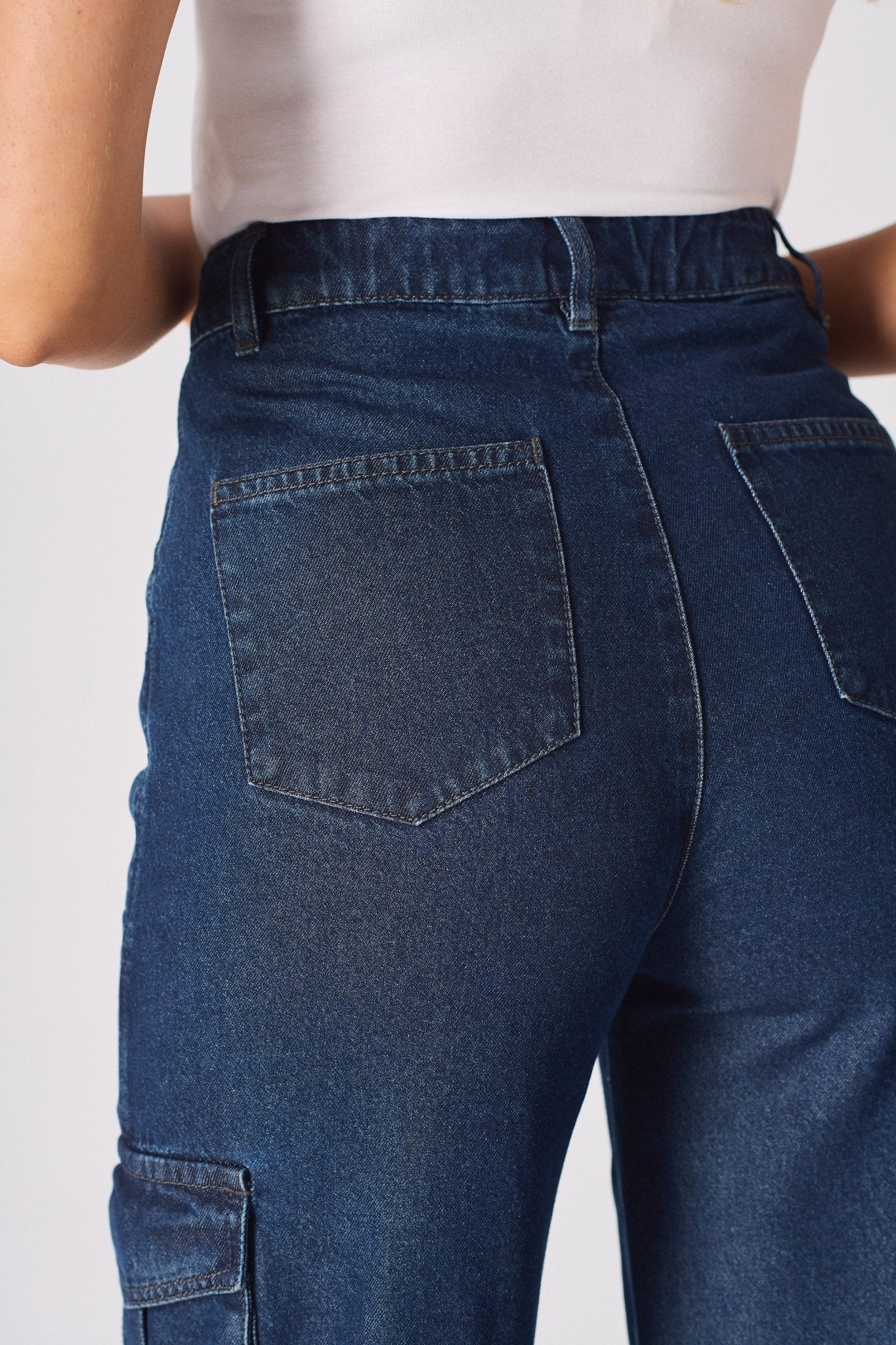 A zoomed in shot of the rear pockets and stitching on the blue high waisted wide leg cargo denim jeans.