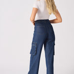 Rear view of a model in blue high waisted wide leg cargo denim jeans women showing the flattering fit.