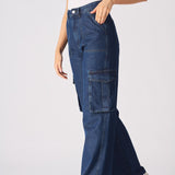 Side profile view of a model walking in blue high waisted wide leg cargo denim jeans women.