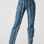 Blue jeans with frayed edges worn by a person on a white background