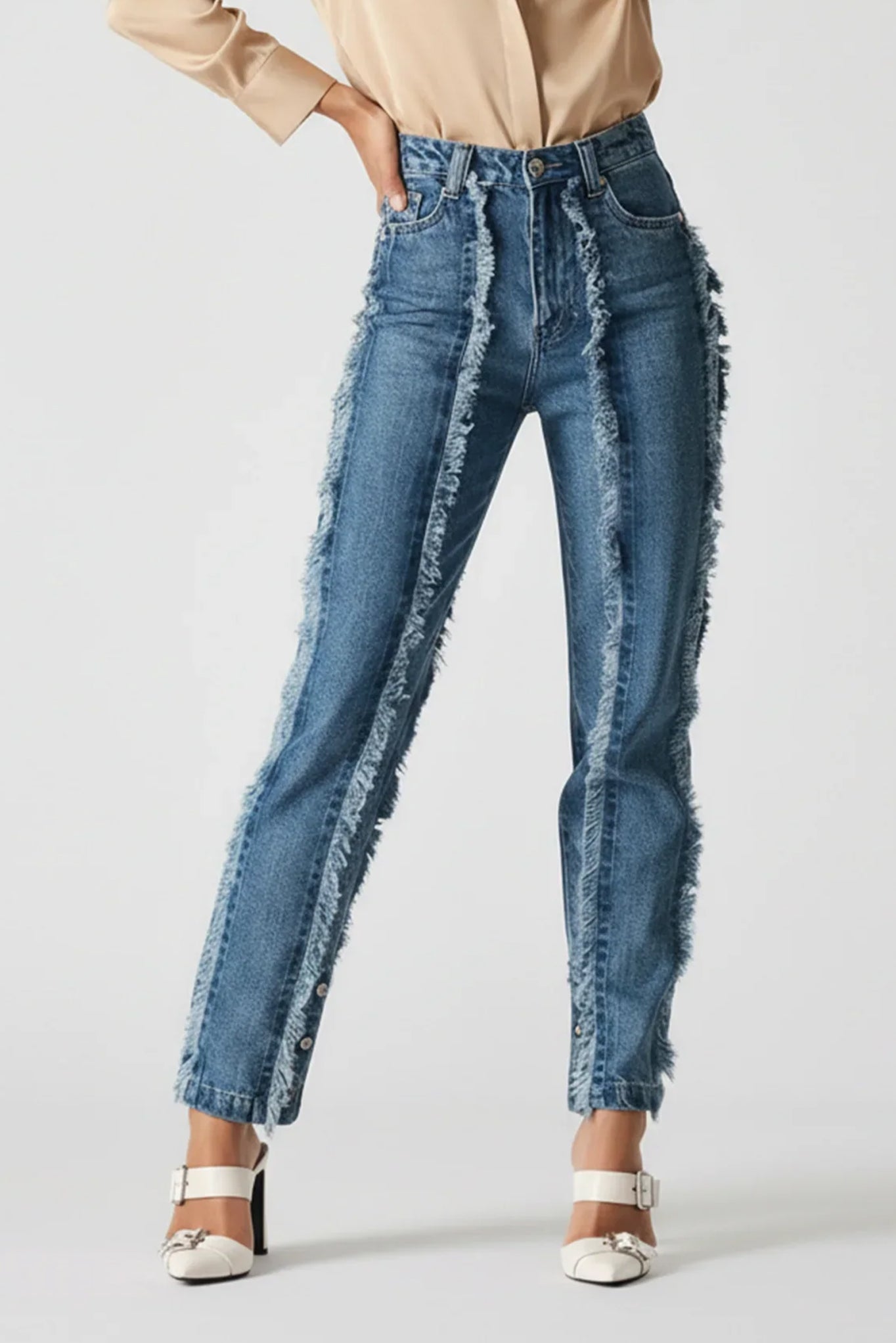 Blue jeans with frayed edges worn by a person on a white background