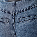 Close-up of blue jeans with a visible brand label on the waistband.
