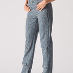Person wearing blue pants with button details on a plain background