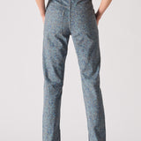 Person wearing blue patterned pants on a plain background